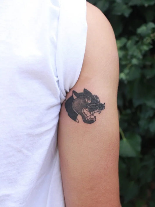 Small Black and Grey Panther Head Tattoo on Women Upper Arm by @josfa_the_tattoo_guy