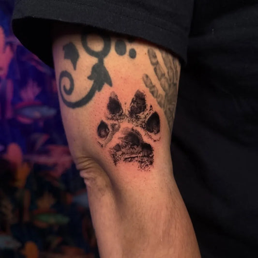 Small Black and Grey Paw Print Tattoo on Men Arm by @symone.tattoo