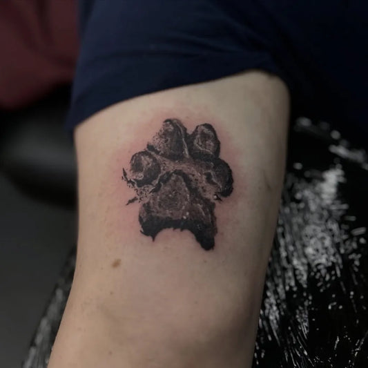 Small Black and Grey Paw Print Tattoo on Men Arm by @tolmantattoo