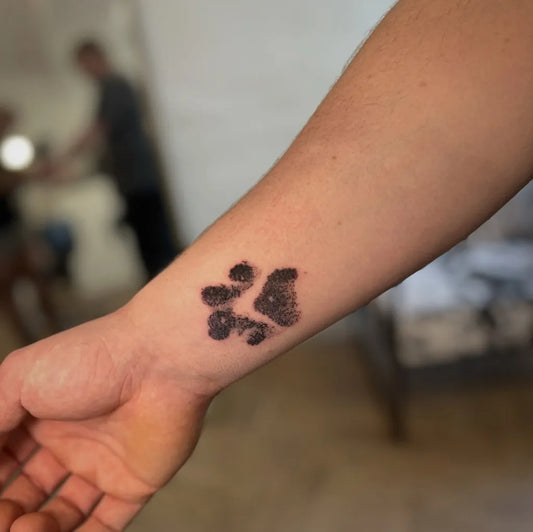 Small Black and Grey Paw Print Tattoo on Men Wrist by @_piggyink_