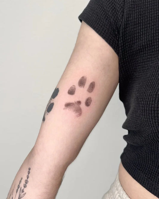 Small Black and Grey Paw Print Tattoo on Women Arm by @soul_imagez_tattoo