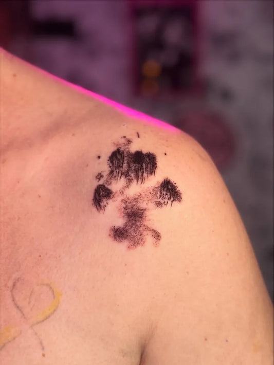 Small Black and Grey Paw Print Tattoo on Women Shoulder by @crissy.vee.tattoo