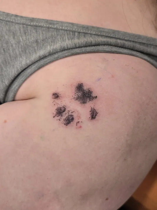Small Black and Grey Paw Print Tattoo on Women Shoulder by @jessiebutterstattoo