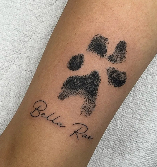 Small Black and Grey Paw Print and Name Tattoo on Women Arm by @vividinkslingers