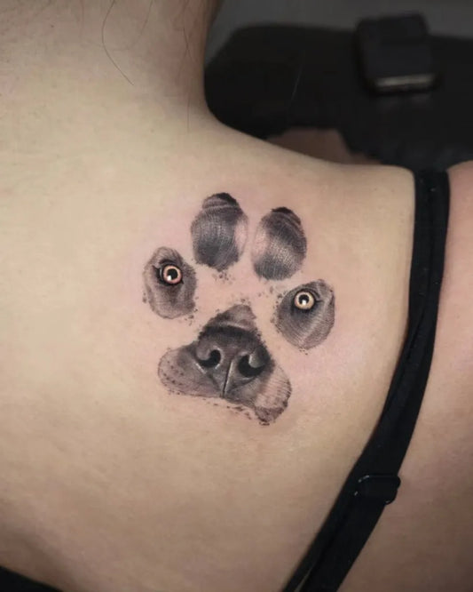 Small Black and Grey Paw Print with Face Tattoo on Women Shoulder by @cien_ink