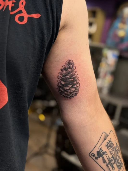 Small Black and Grey Pine Cone Nature Tattoo on Men Arm by @vividinkbirmingham