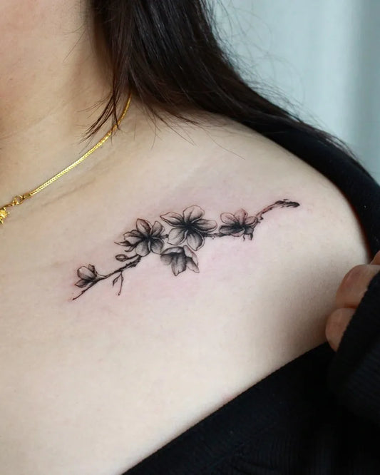Small Black and Grey Plum Blossom Tattoo on Women Collarbone by @grantlutattoo