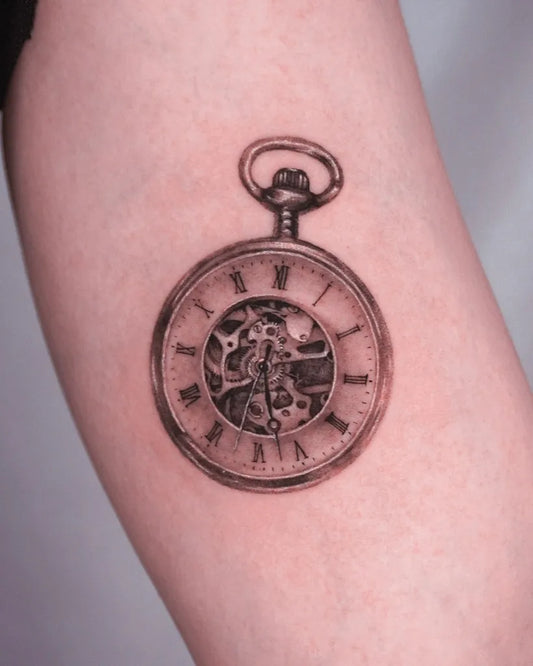Small Black and Grey Pocket Watch Tattoo on Women Arm by @dokdan.tt