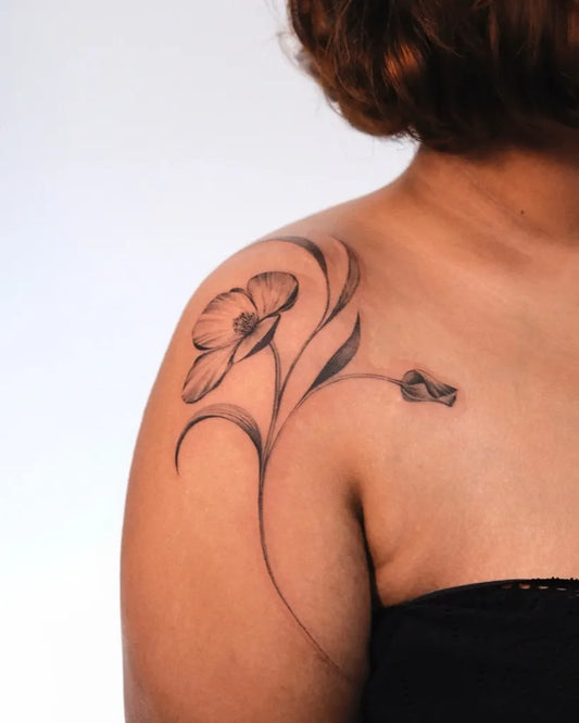 Small Black and Grey Poppy Flower Tattoo on Women Shoulder by @its.freegee