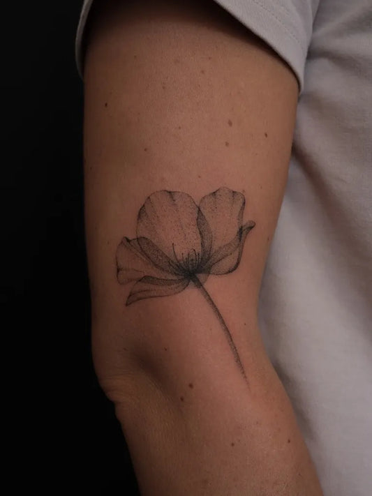 Small Black and Grey Poppy Tattoo on Women Arm by @elinarttattoo