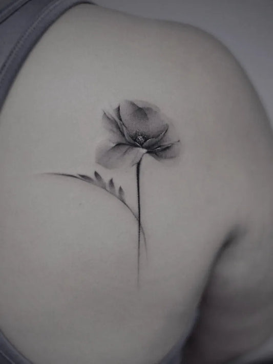 Small Black and Grey Poppy with Stem Tattoo on Women Shoulder by @w.w.tatt