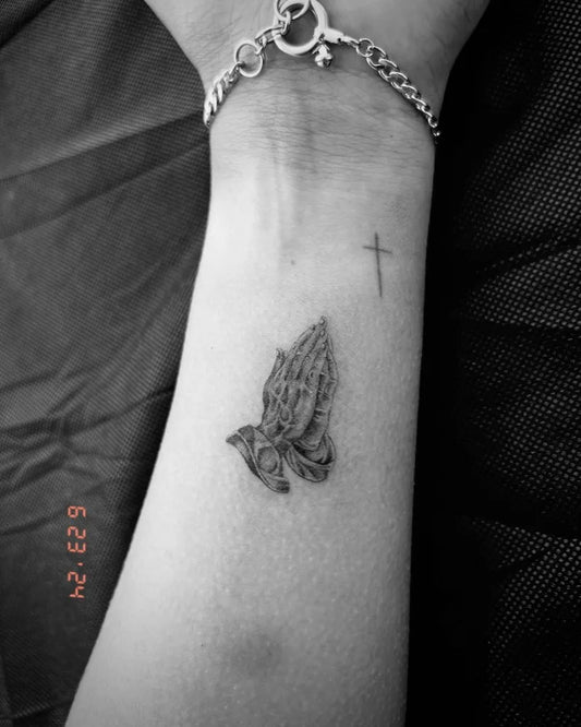 Small Black and Grey Praying Hands with Dove Tattoo on Women Wrist by @gordn.ink