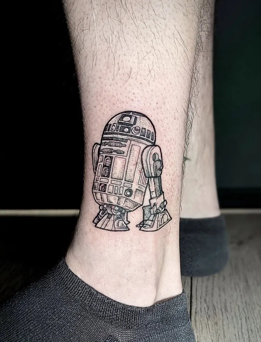 Small Black and Grey R2 D2 Star Wars Tattoo on Men Leg by @mato_tattooer