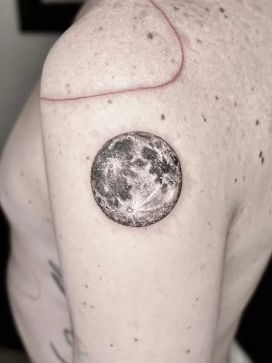 Small Black and Grey Realism Moon Tattoo on Women Shoulder by @annamillertattoo