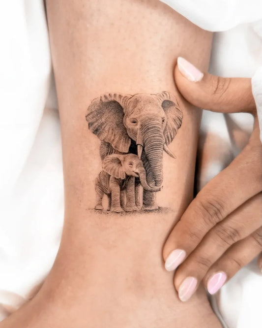 Small Black and Grey Realism Mother and Son Elephant Tattoo on Women Ankle by @1991.ink