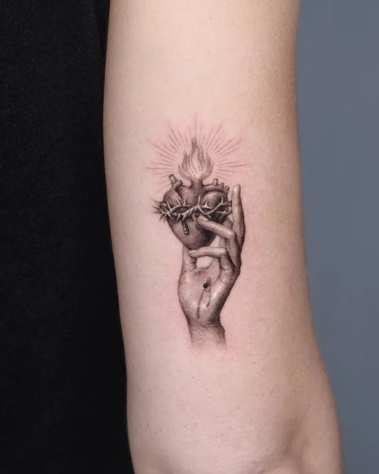 Small Black and Grey Sacred Heart with Hand Tattoo on Women Arm by @40.tatt