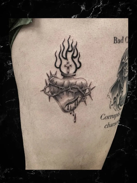 Small Black and Grey Sacred Heart with Thorns and Flames Tattoo on Men Upper Arm by @r.medina.tattoos