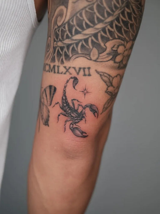 Small Black and Grey Scorpion and Roman Numerals on Men Arm Tattoo by @eddiexbird