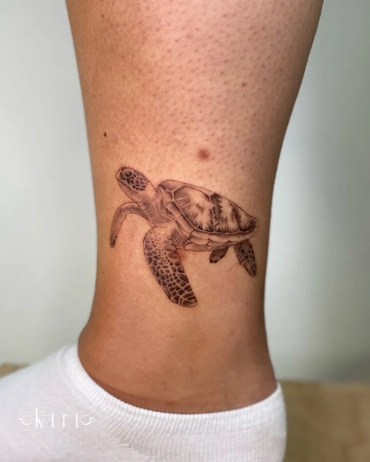 Small Black and Grey Sea Turtle Tattoo on Women Ankle by @kiri.vrs