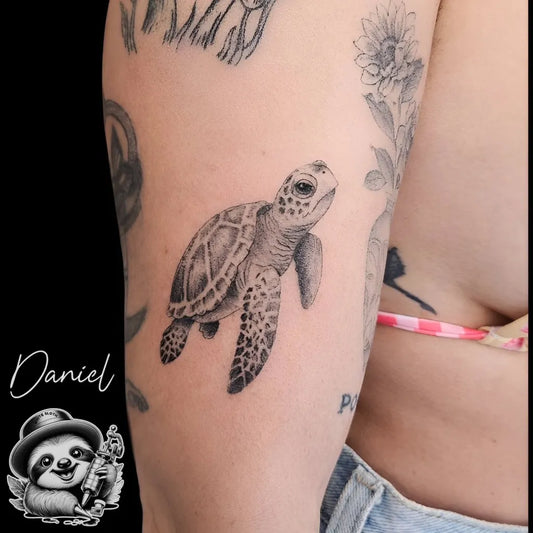 Small Black and Grey Sea Turtle Tattoo on Women Arm by @whitesloth.tattoo