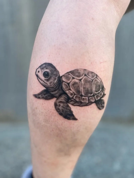 Small Black and Grey Sea Turtle Tattoo on Women Leg by @mikeramostattoos