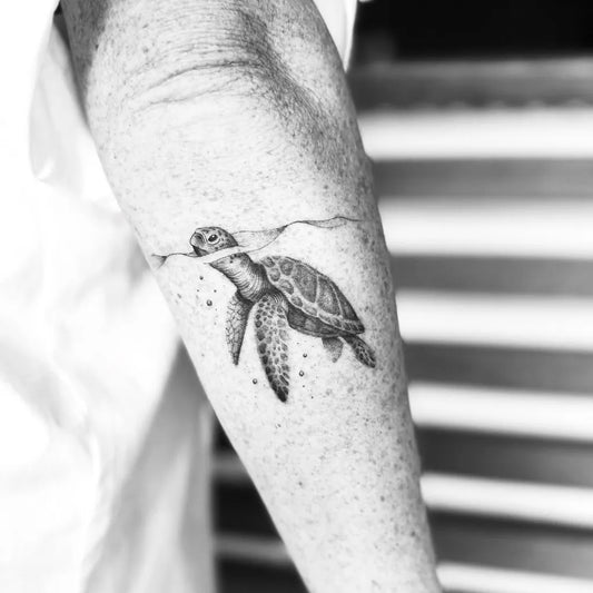 Small Black and Grey Sea Turtle and Water Tattoo on Men Arm by @reni.tattoo_