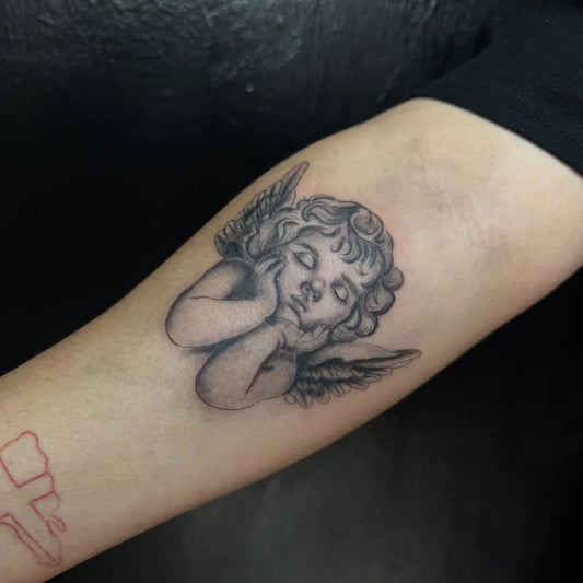 Small Black and Grey Sleeping Cherub Angel on Women Arm Tattoo by @allytatz