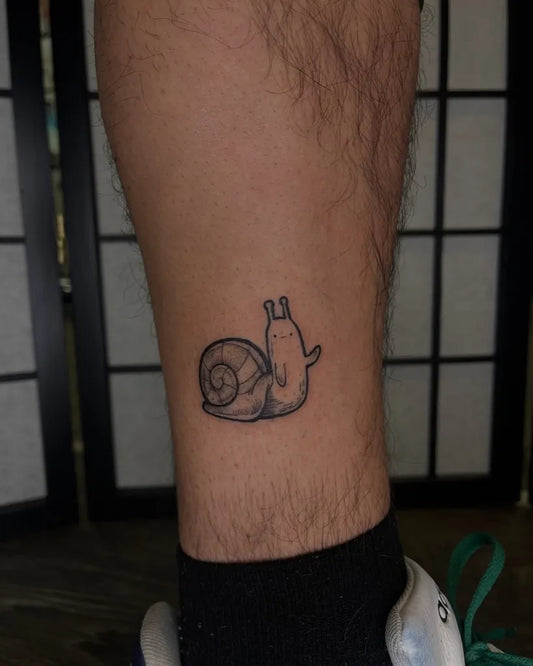 Small Black and Grey Snail Cartoon Tattoo on Men Leg by @brandonartmendes