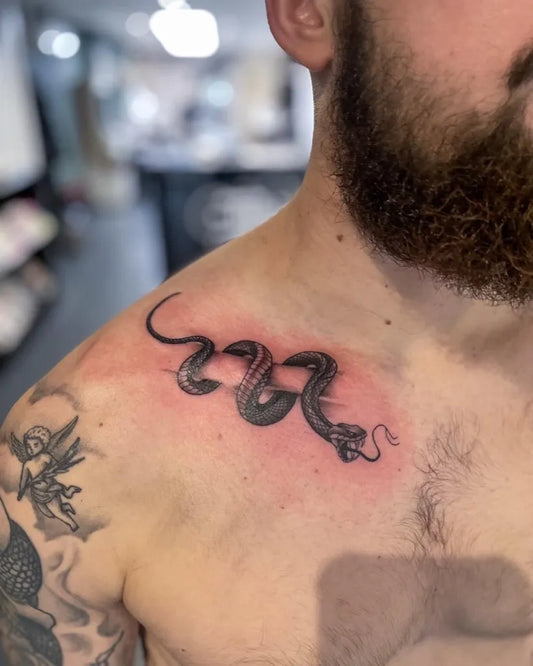 Small Black and Grey Snake Tattoo on Men Collarbone by @inkredibletattoos
