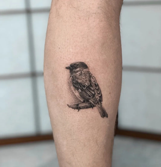 Small Black and Grey Sparrow Tattoo on Men Leg by @eligraff.tattoo