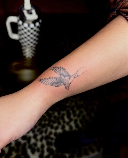 Small Black and Grey Sparrow Tattoo on Women Forearm by @inkedby.liz