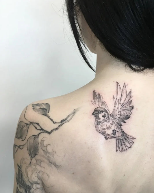 Small Black and Grey Sparrow with Branch Tattoo on Women Shoulder by @kaotica_gabriela_tattoo