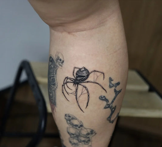 Small Black and Grey Spider and Skulls on Women Leg Tattoo by @kayatatt