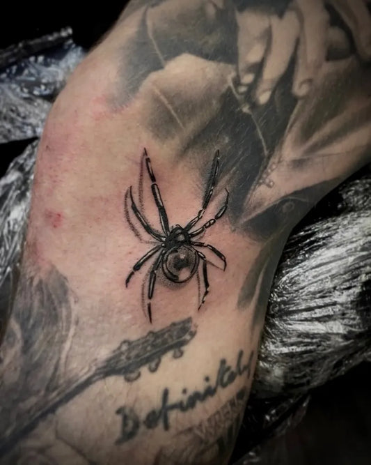 Small Black and Grey Spider on Men Leg Tattoo by @montagueandcapulettattoo