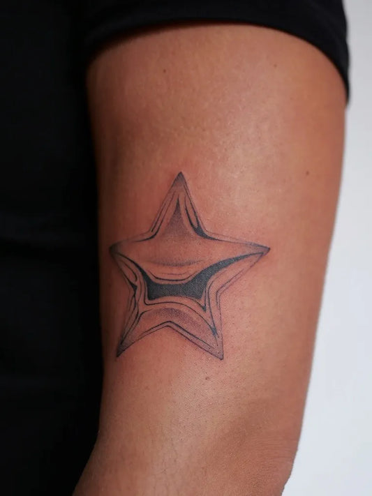 Small Black and Grey Star Tattoo on Men Upper Arm by @taiyo__lee