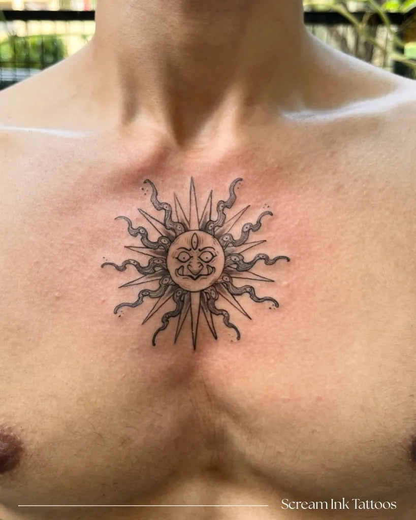 Small Black and Grey Sun with Lotus on Men Chest Tattoo by @screaminktattoos_