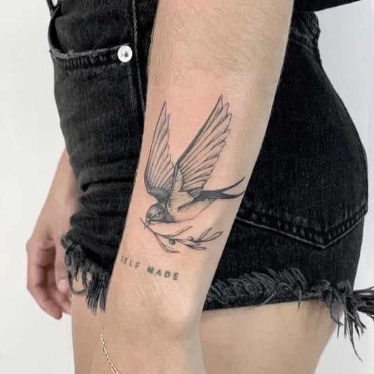 Small Black and Grey Swallow Bird and Self Made Women Arm by @trl.tattoo