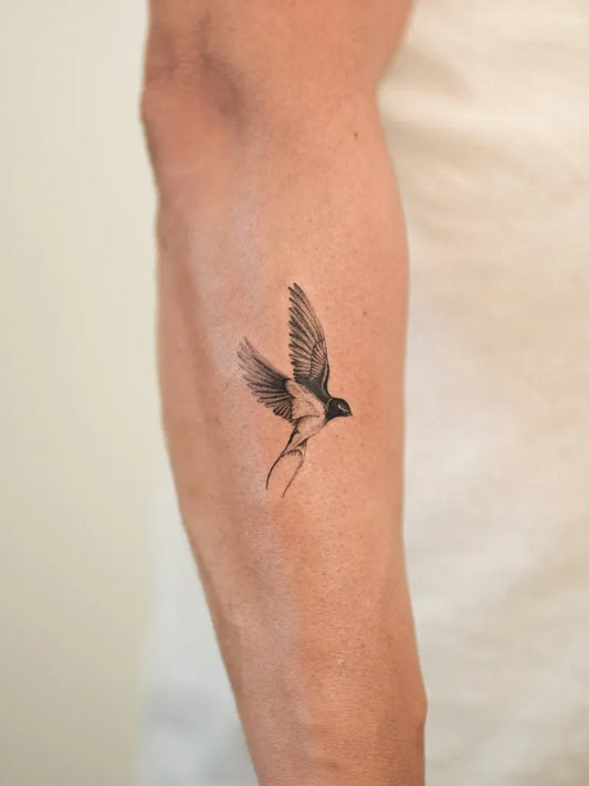 Small Black and Grey Swallow Tattoo on Men Arm by @cipri.tatt