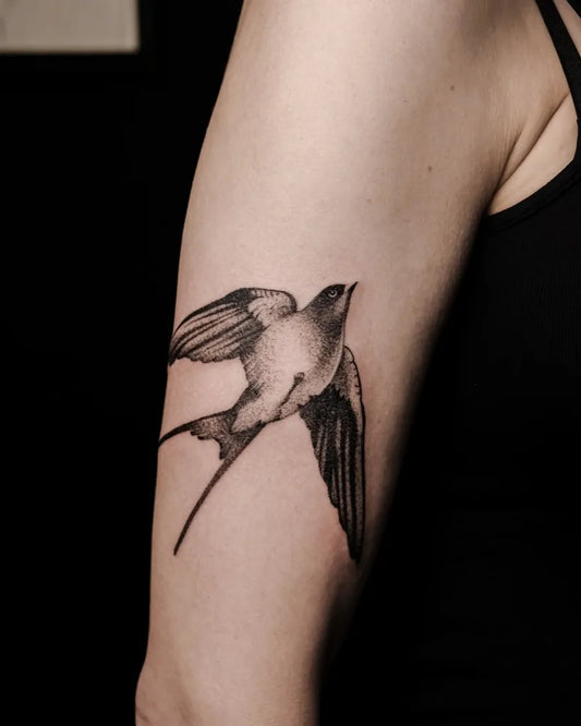 Small Black and Grey Swallow Tattoo on Women Arm by @petra.tattooing