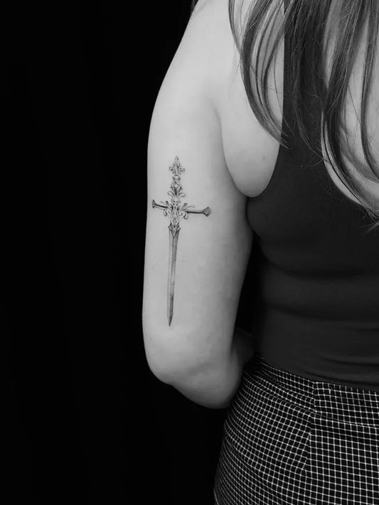 Small Black and Grey Sword Cross on Women Arm Tattoo by @imokay.art