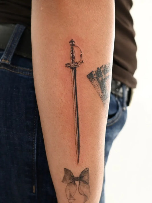 Small Black and Grey Sword on Women Arm Tattoo by @softchicktattoo