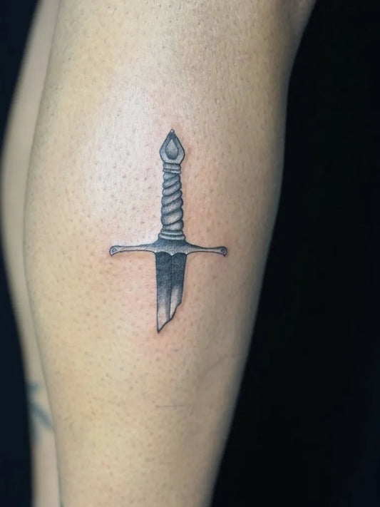 Small Black and Grey Sword on Women Leg Tattoo by @inkbysana