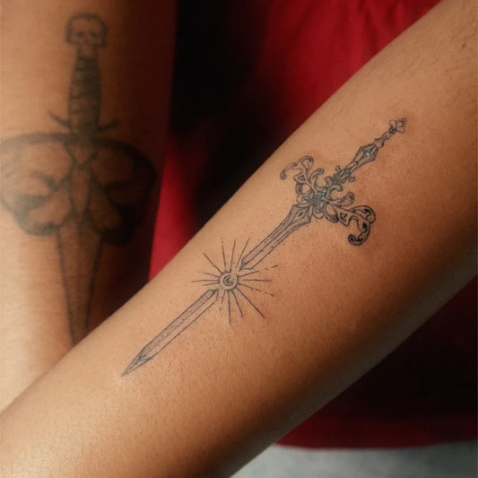 Small Black and Grey Sword with Starburst on Women Arm Tattoo by @artashtray
