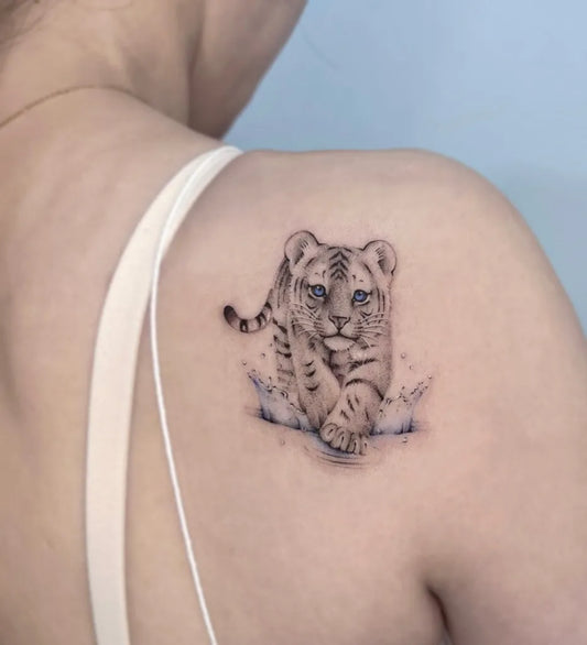 Small Black and Grey Tiger Cub with Splash on Women Shoulder Tattoo by @jannabi_tatt