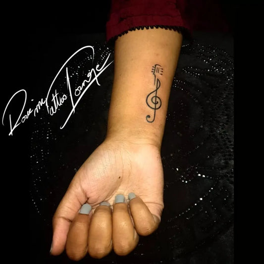 Small Black and Grey Treble Clef Tattoo on Women Wrist by @rockinktattoolounge