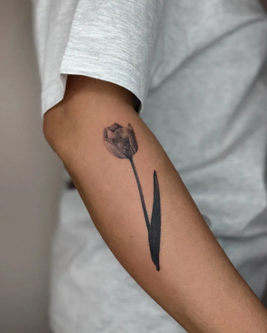 Small Black and Grey Tulip Tattoo on Men Arm by @ingaoberda.tattoo