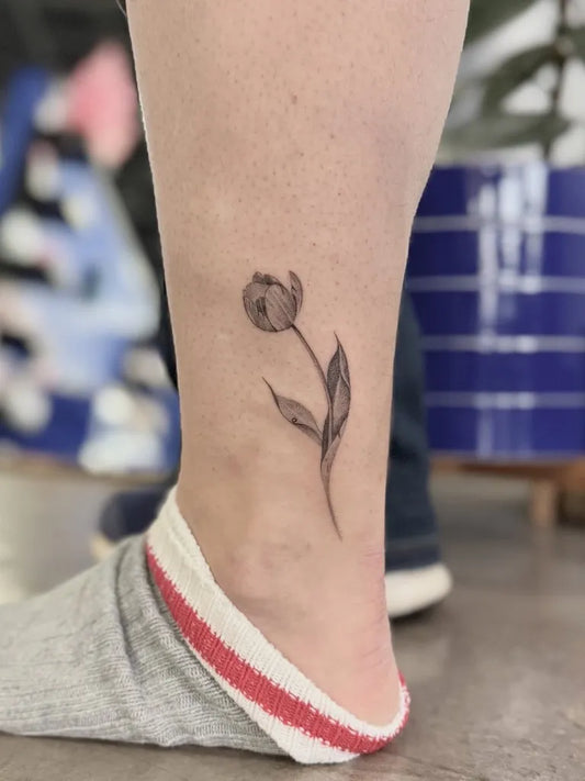 Small Black and Grey Tulip Tattoo on Women Ankle by @chytattoos