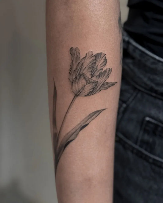 Small Black and Grey Tulip Tattoo on Women Arm by @kavi_tattoo