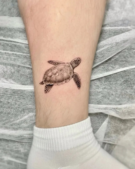 Small Black and Grey Turtle Tattoo on Men Leg by @daytwelvetattoostudio