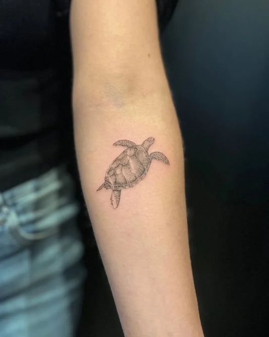 Small Black and Grey Turtle Tattoo on Women Forearm by @delamartattoo